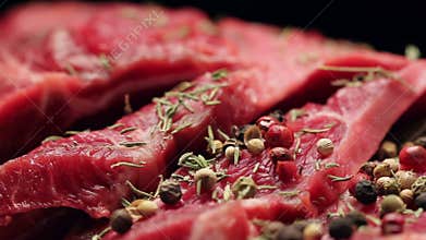 Fresh raw beef meat with peppercorns ready to grill, rotating