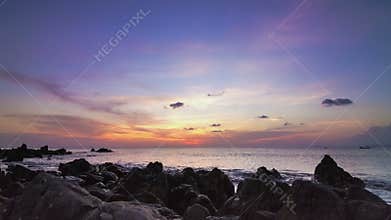 Sea sunset on rock shore pan time lapse