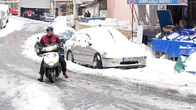 ISTANBUL, TURKEY - FEBRUARY 2015: scooter courier riding, snowy streets