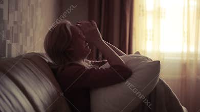 Depressed woman in bed. girl crying on the couch. acute mountain