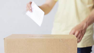 Man putting his vote into ballot box on election