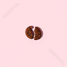 One broken piece gluten free chocolate protein energy bar cookie on pink background. Healthy vegan super food, fitness dieting