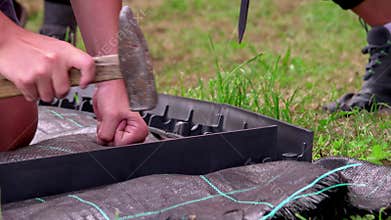 Young children constructing a path, laying delimiter panel