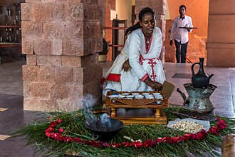 Lalibela, Ethiopia - Feb 14, 2020: Young woman in traditional clothing is preparing a coffee ceremony