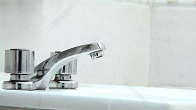 Water Dripping From The Faucet in The Bathroom at Home.- Close Up.