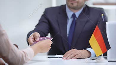 German consular officer giving passport to woman, refugee visa, asylum status