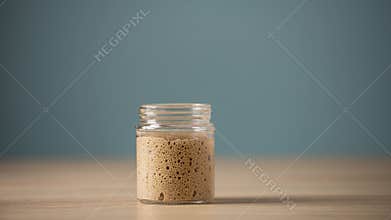 Starter yeast rising in a glass jar