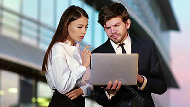 Sales people working on a laptop outside.