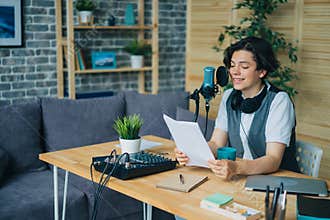 Smiling boy reading aloud in microphone recording podcast in modern studio