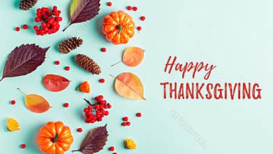 Happy Thanksgiving greeting card with leaves, pumpkins, rowan berries on mint background. Fall, thanksgiving concept