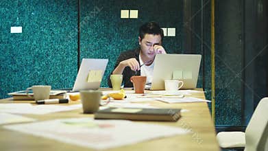 Young asian businessman working late in office