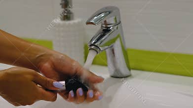 Slow motion. makeu p brush. Woman washing dirty makeup brush with soap and foam in the sink