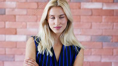 Positive woman near brick wall