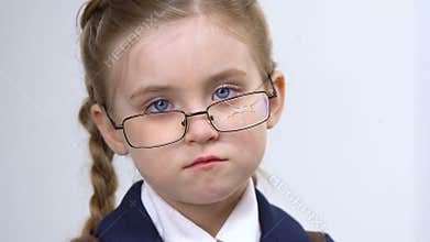 Upset girl in broken glasses looking at camera closeup, school bullying, abuse