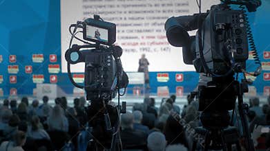 The cameraman makes video for television. Auditorium, seminar and lecture on business. Professional ideas, politics or