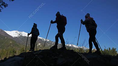 Woman do Nordic walking in nature on mountain. Silhouette. Girls and children use trekking sticks and nordic poles