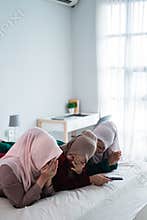Asian hijab woman with friends cover face because of fear when watching horor film