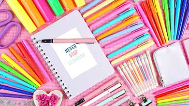 Back to school or workspace colorful stationery overhead on pink flatlay.