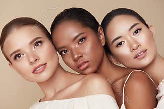 Diversity. Beauty Portrait Of Different Ethnicity Women. Multi-Ethnic Models Standing Together Against Beige Background.