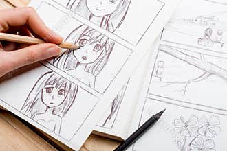 Artist drawing an anime comic book in a studio