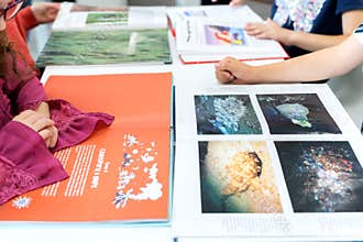 Russia Moscow 25.09.20 Schoolkids read book about sea animals, fish with illustrations in children`s library.Special reading kids