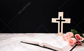 Church composition with wooden cross , bible and Beautiful pink flowers on white background