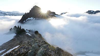 Morning light high above the cloud layer on Mount Rainier. Beautiful Paradise area, Washington state, USA in the fall with snow