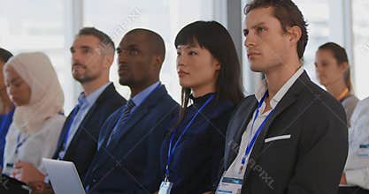 Audience at a seminar raising hands to ask questions