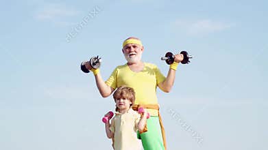 Grandfather and child lifting dumbbell. Healthy life and sport concept. Grandfather helping kid exercising with