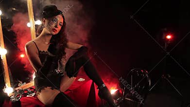 Burlesque style girl smokes a cigar