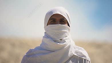 Bedouin in white clothes looking on camera, islamic religion and traditions
