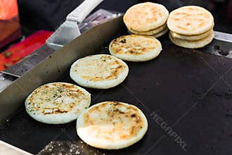 Arepas, Colombian corn patties filled with cheese, at a street food market.
