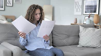 Curly Hair Woman Reading Documents while Sitting on Couch