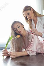 Young lesbian couple on floor touch and sensuality