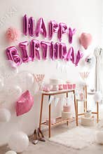 Phrase HAPPY BIRTHDAY made of pink balloon in decorated room