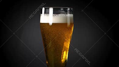 Beer poured into a glass on a black background