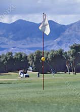 A white golf flag blowing in the wind
