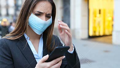 Executive wearing mask checking news on phone