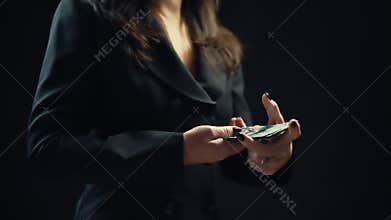 Close up, young woman businessman is counting money, on black background. 4k