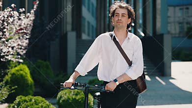 Business man is going to the business centre wearing informal suit, carrying the electric bicycle. Eco-friendly modern