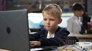 Portrait of boy programming software for robotics