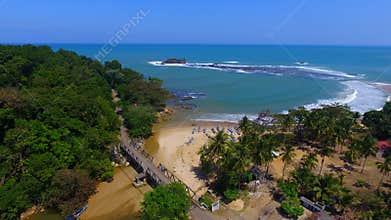 A bridge entering the rain forest near the beach and the smallet island in Infonesia