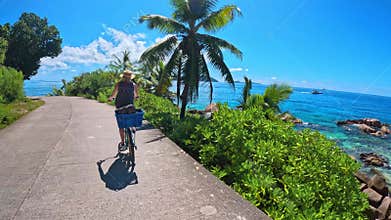 Biking traveler with rental bike on the island of La Digue, Seychelles.
