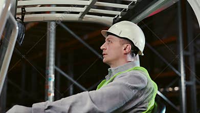 Logistic Guy Caucasian Worker Operating Forklift at Logistic Center Inside. People at Work