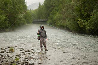 man fishing in river fighting fish in river alaska