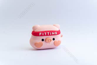 Pink rubber piglet figurine with exercise headband in isolated white background.