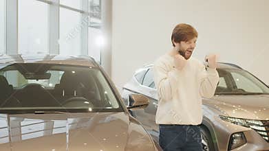 Happy car owner rejoices in buying a new luxury electric car. Man giving keys of car to buyer. Car agent and customer in