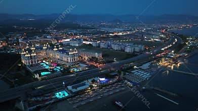 Stunning aerial sunset to night transition over Turkler in Alanya, Turkey. Alanya coastline,resorts,marina,hotels and city lights
