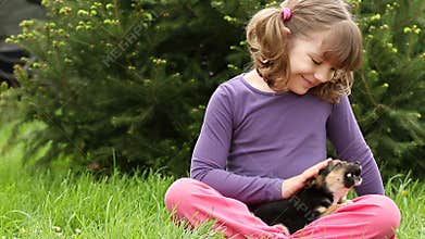 Little girl feeding puppy