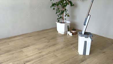 Cleaning supplies being used to clean a wooden floor
